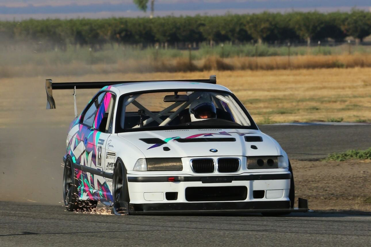White BMW E36 race car with hood vent kit on track