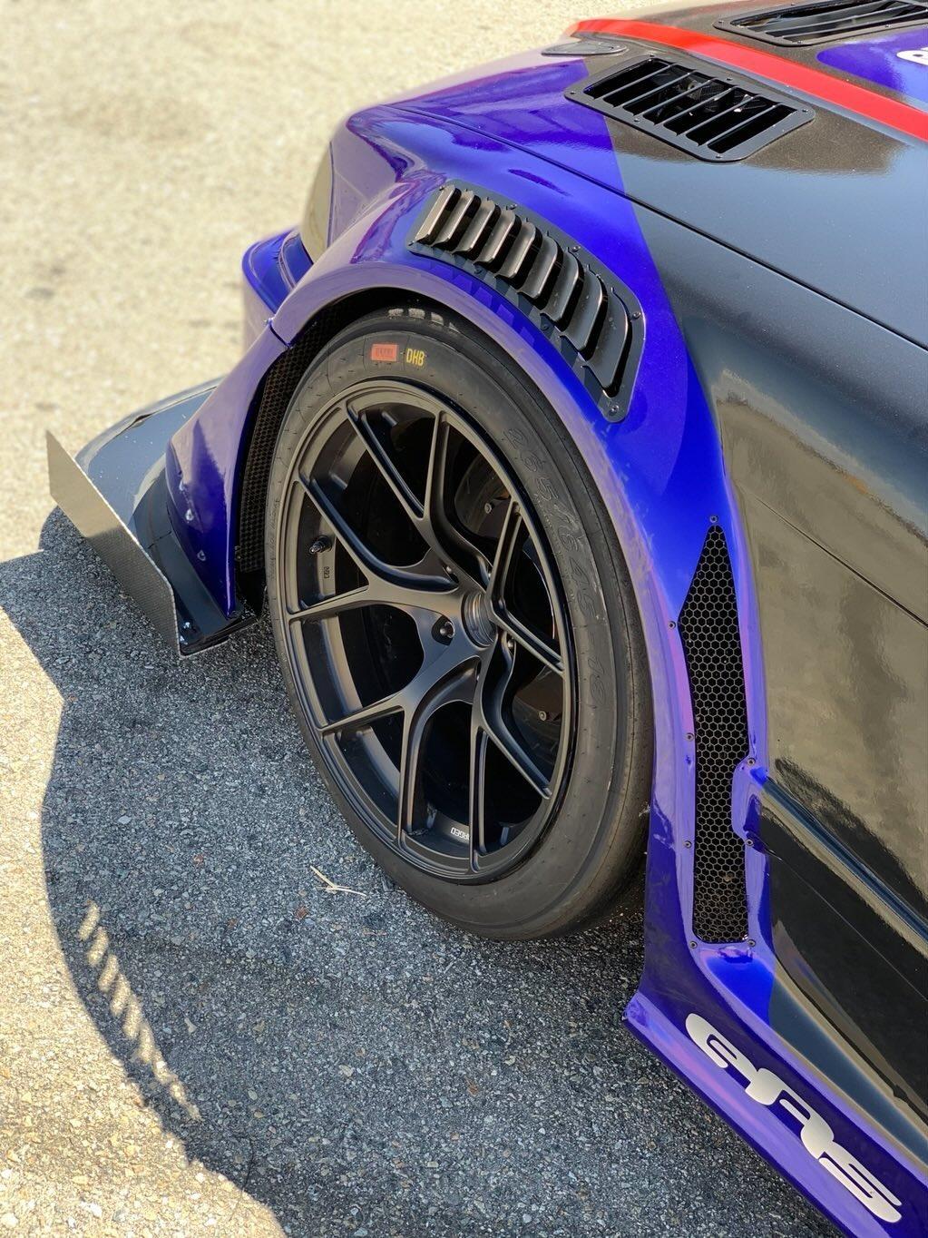 Universal fender vents on the front fender arch of a blue race car
